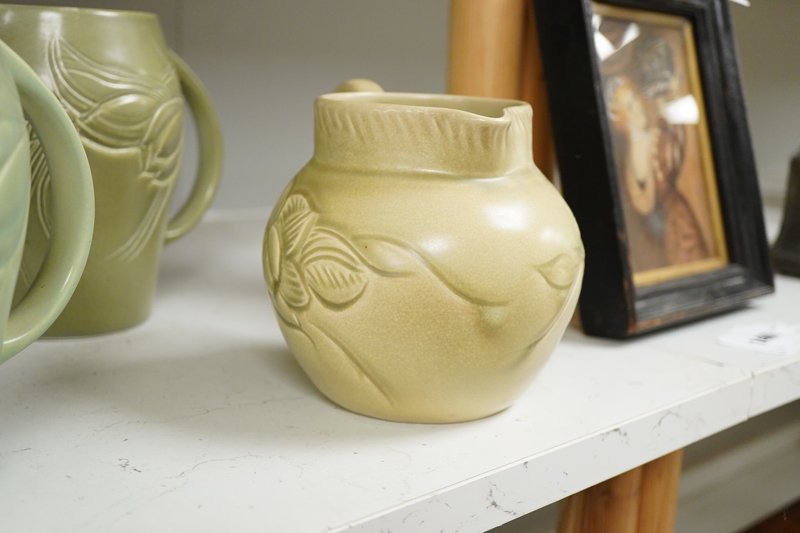 Three Susie Cooper green floral incised jugs, signed to the bases, tallest 16cm high